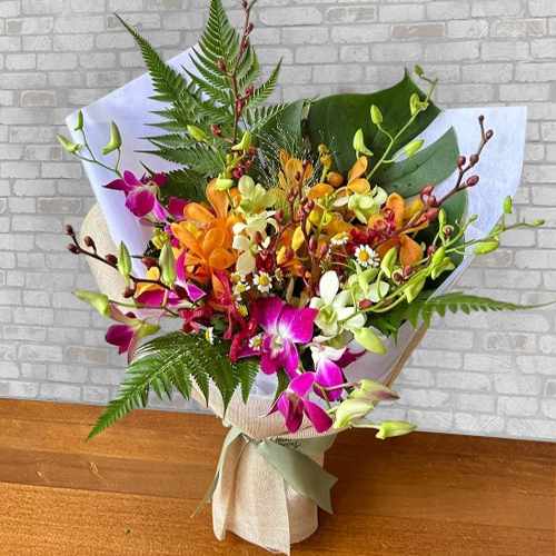 Tropical Radiance Orchid Arrangement With Lush Foliage